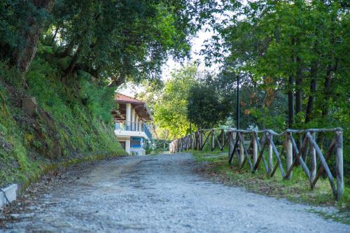 a dirt road with a fence next to a house at Villa Ginevra Resort Agrituristico in Ficarra
