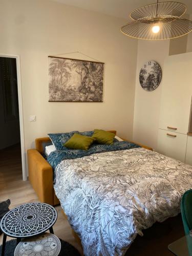 une chambre avec un lit et un tableau au mur dans l'établissement Magnifique appartement au centre ville avec parking privé et gratuit LE JARDIN DES PLANTES, à Dijon