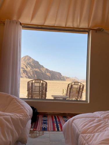 a bedroom with a view of the desert from a window at Rum Jordan camp and tours in Wadi Rum
