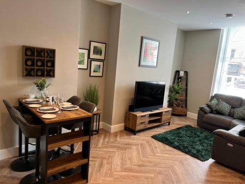 a living room with a table and a television at Crown and Cushion Appleby in Appleby