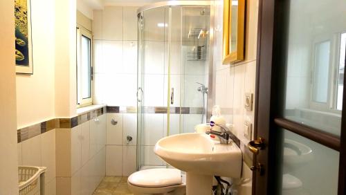 a bathroom with a toilet and a sink and a shower at Central Loft in Tirana