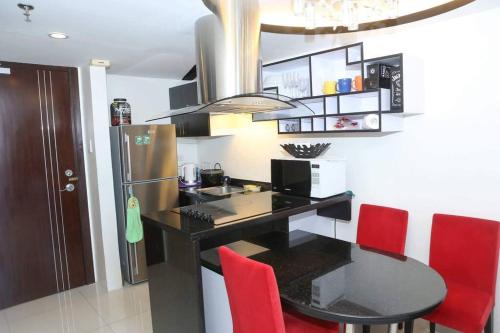 a kitchen with a black table and red chairs at Huge Loft Type Condo At Queen City of the South in Cebu City