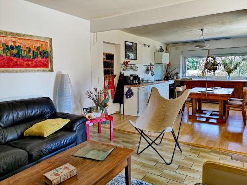 uma sala de estar com um sofá de couro preto e uma mesa em Propriété avec piscine de 2 à 9 personnes, Gîte De Saint Donat, em La Roque-Gageac