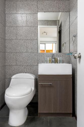 a bathroom with a toilet and a sink and a mirror at Cabañas Rio Rapel in Rapel