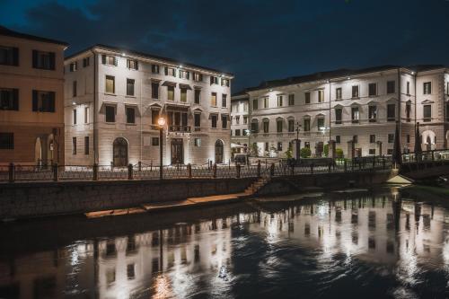 a bridge over a river in a city at night at Le Camere di Palazzo Bortolan in Treviso