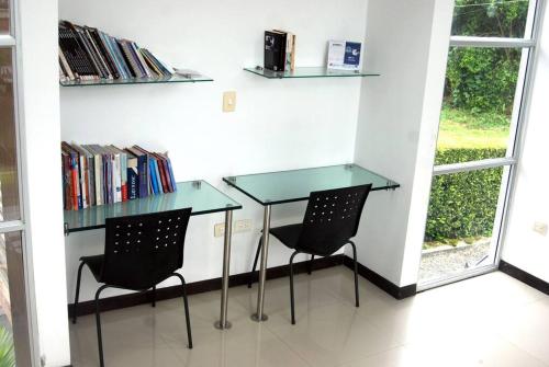 a glass table and two chairs in a room at CASA VACACIONAL CAPINA87 in Pereira
