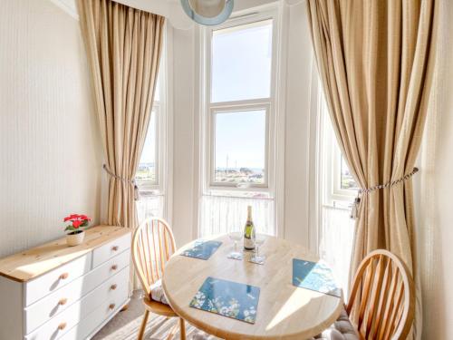 a dining room with a table and chairs and a window at Apartment 1 Large Studio Sea Front- Sea Views- Free Parking in Paignton