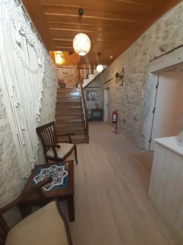 アラカティにあるMerlara Otel Alaçatıの階段、椅子、テーブルが備わる客室です。