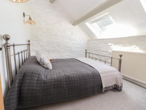 a bedroom with a bed with a gray comforter at The Coach House in Llangollen