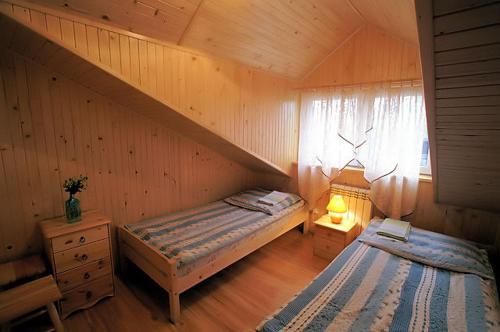 a bedroom with two beds in a wooden cabin at Gospodarstwo Agroturystyczne U Zdzicha in Bałtów
