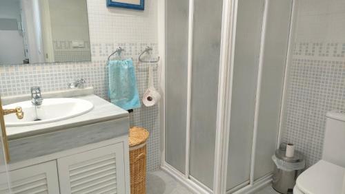 ein weißes Bad mit einem Waschbecken und einer Dusche in der Unterkunft Fairway Vista La Finca in Málaga