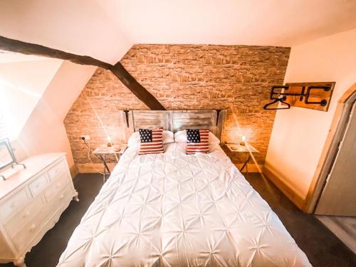 una camera da letto con un grande letto bianco con due cuscini di The Loft at Riverside Suites Bridgnorth a Bridgnorth