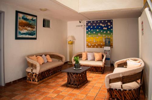 曼薩尼約的住宿－Hotel Caracoles，客厅配有两把椅子和一张桌子