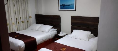 ein Hotelzimmer mit 2 Betten und einem Fenster in der Unterkunft HOSTAL CORAL in Ilo