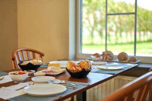 una mesa con platos y tazones de comida. en B&B Abdeshof, en Middelkerke