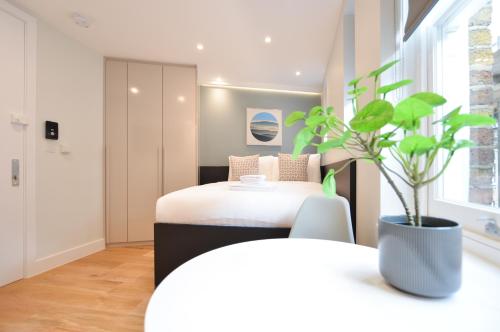 a bedroom with a bed and a potted plant at StayPrime Marylebone Serviced Apartments in London