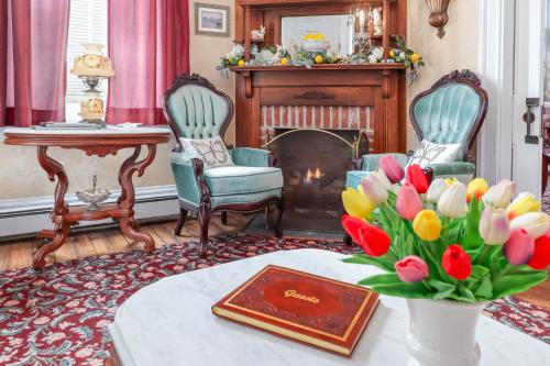 a living room with two chairs and a table with flowers at Bedford Inn in Cape May