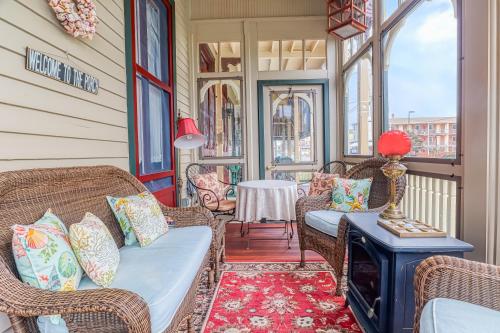 une terrasse couverte avec des chaises en osier et une cheminée dans l'établissement Bedford Inn, à Cape May