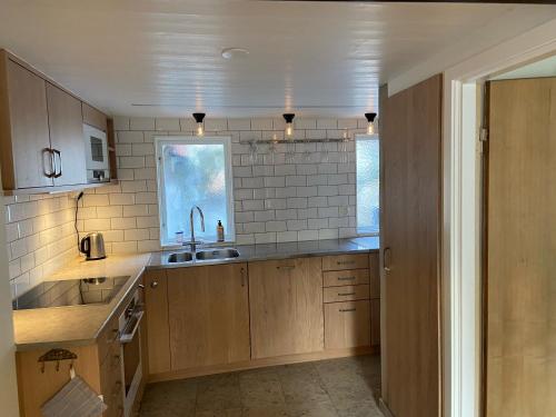 una cocina con armarios de madera y fregadero en Visby City Apartments S:t Hansgatan, en Visby
