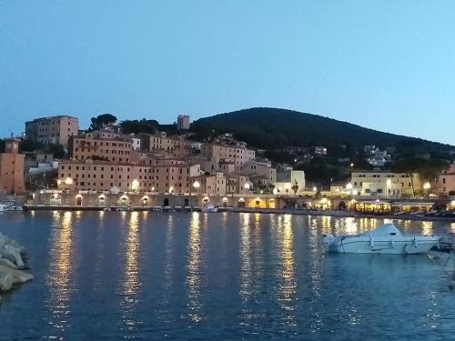 a town on the water at night at villetta dei fichi d'India in Rio nellʼElba