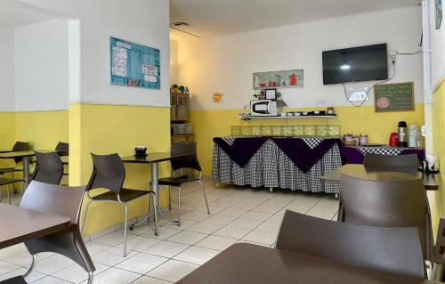 クリチバにあるHotel Blumenau Centroのテーブルと椅子、カウンター付きのレストラン