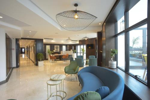 a lobby with a blue couch and a table and chairs at MAIA HOTEL SUITES in Tunis