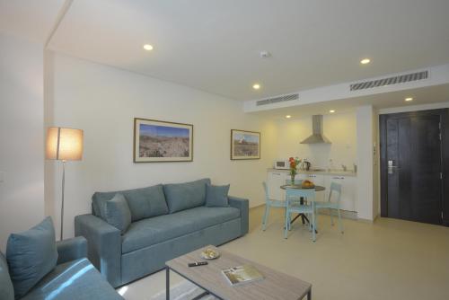 a living room with a blue couch and a table at MAIA HOTEL SUITES in Tunis