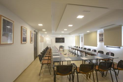 a large room with tables and chairs and a screen at MAIA HOTEL SUITES in Tunis