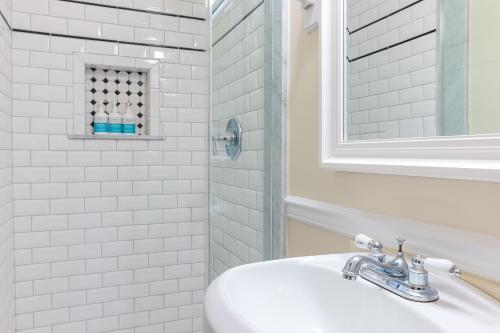 a white bathroom with a sink and a shower at Bedford Inn in Cape May