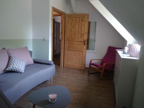a living room with a blue couch and a table at Ferienwohnung Fuchsberge in Letschin