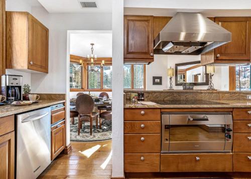 a kitchen with wooden cabinets and a dining room at 323 Beaver Creek Lodge in Avon