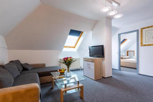 a living room with a couch and a tv at Trip Inn Kongresshotel Frankfurt-Rodgau in Rodgau