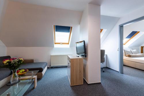 a living room with a couch and a tv at Trip Inn Kongresshotel Frankfurt-Rodgau in Rodgau