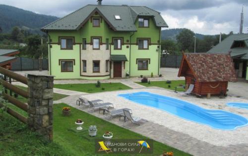 a house with a swimming pool in front of it at Emerald House in Mykulychyn