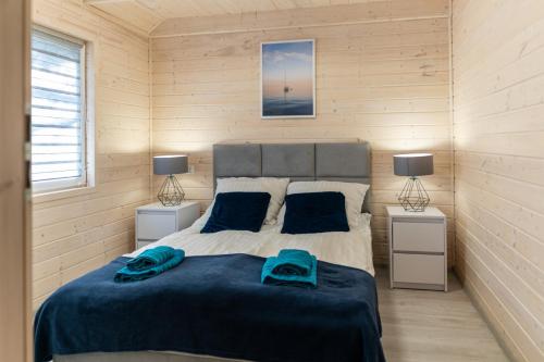 a bedroom with a bed with two night stands and two lamps at Biały Szafir in Rusinowo