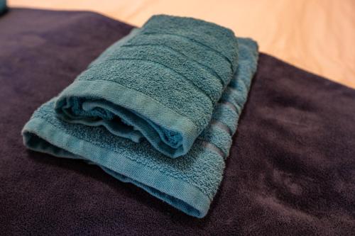a green towel sitting on top of a bed at Biały Szafir in Rusinowo