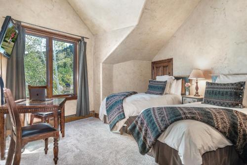 a bedroom with two beds and a desk and a window at A6 Village Townhouse in Edwards