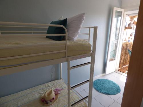 Ce lit superposé se trouve dans un dortoir doté d'une porte. dans l'établissement Coquet T2 climatisé, véranda vue mer, Le Caounil, St Pierre la Mer, à Saint Pierre La Mer