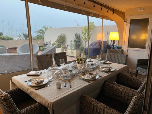 - une table avec des verres et des assiettes sur la terrasse dans l'établissement Appartement port hyères, à Hyères