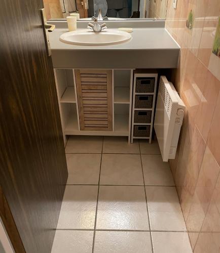 La salle de bains est pourvue d'un lavabo et d'un comptoir. dans l'établissement Maison dans résidence 3*proche plage, à Saint-Cyprien