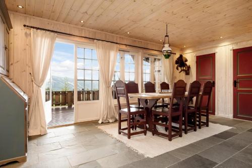 a dining room with a table and chairs and a large window at ReveEnka - cabin in Trysil with Jacuzzi for rent in Trysil