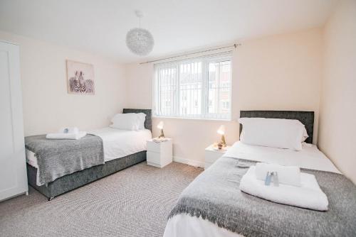 a bedroom with two beds and a window at Potter Apartment in Doncaster