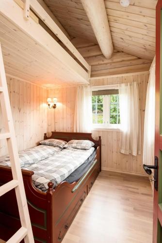 a bedroom with a bed with a ladder and a window at ReveEnka - cabin in Trysil with Jacuzzi for rent in Trysil