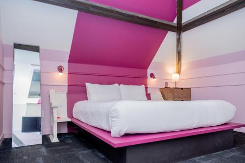 a bed in a room with a pink wall at The Russell in Nashville