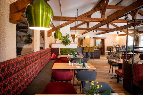 ein Restaurant mit Holztischen und -stühlen und einem grünen Anhänger in der Unterkunft Hotel Bürglstein in St. Wolfgang