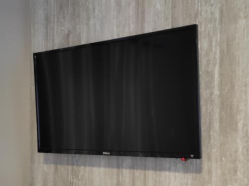 TV de pantalla plana colgada en la pared en Residencial Recanto Verde, en Canela