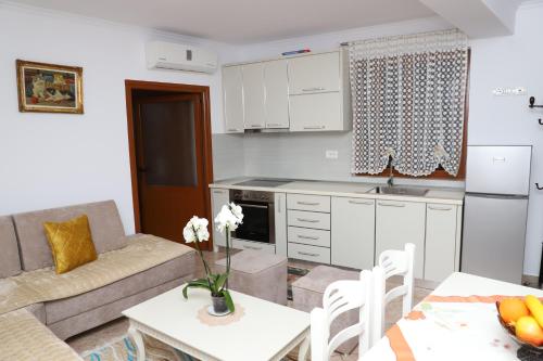 kuchnia i salon z kanapą i stołem w obiekcie Downtown Apartment 2 w mieście Berat