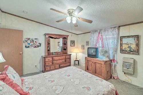 a bedroom with a bed with a ceiling fan and a television at Greers Ferry Getaway with Deck and Lake Access! in Fairfield Bay