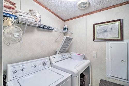 a laundry room with a washing machine and a fan at Greers Ferry Getaway with Deck and Lake Access! in Fairfield Bay