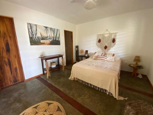 um quarto com uma cama e uma cabeceira em madeira em Casa Tropical Taiba em Taíba